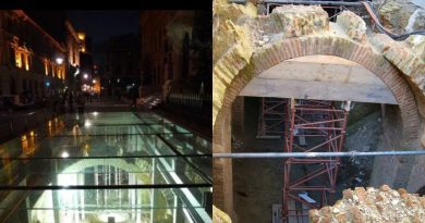 Vestigii arheologice sub sticlă pe o stradă iluminată noaptea și arc roman restaurat cu schele de susținere