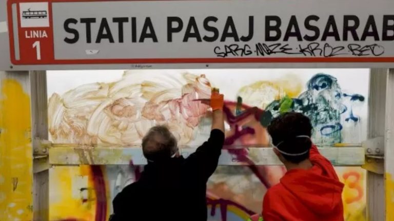 Voluntari curăță graffiti-ul de pe panourile de la Stația Pasaj Basarab, București