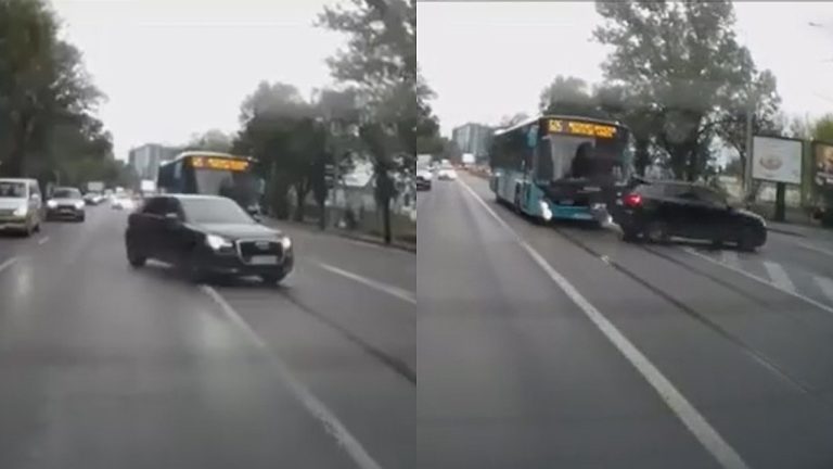 Accident rutier între un autobuz și o mașină neagră pe o stradă aglomerată.