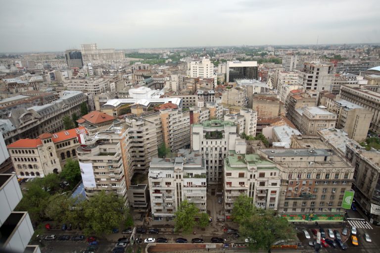 Vedere panoramică asupra centrului Bucureștiului, cu clădiri rezidențiale și administrative, inclusiv Palatul Parlamentului în fundal