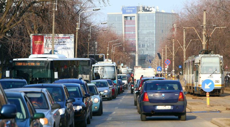 Trafic aglomerat în București cu mașini, autobuz și tramvai pe o arteră principală