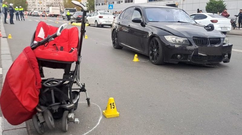 Accident rutier grav între un BMW negru și un cărucior roșu de copil pe o stradă urbană, investigat de poliție.