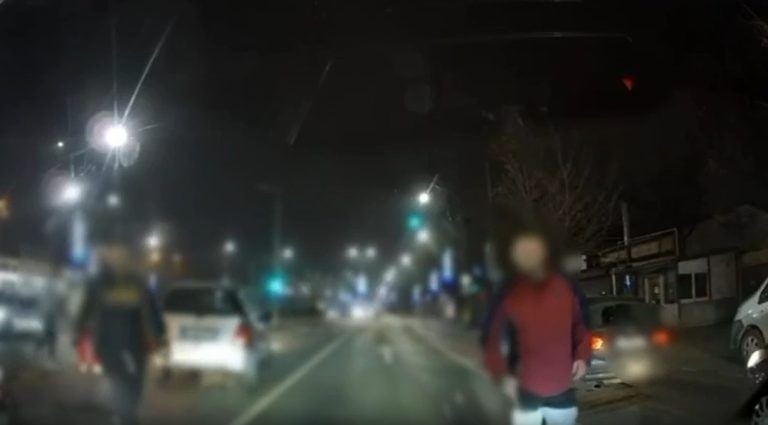 Bărbat pe carosabil în timpul nopții, surprins de camera auto într-o situație de trafic aglomerat