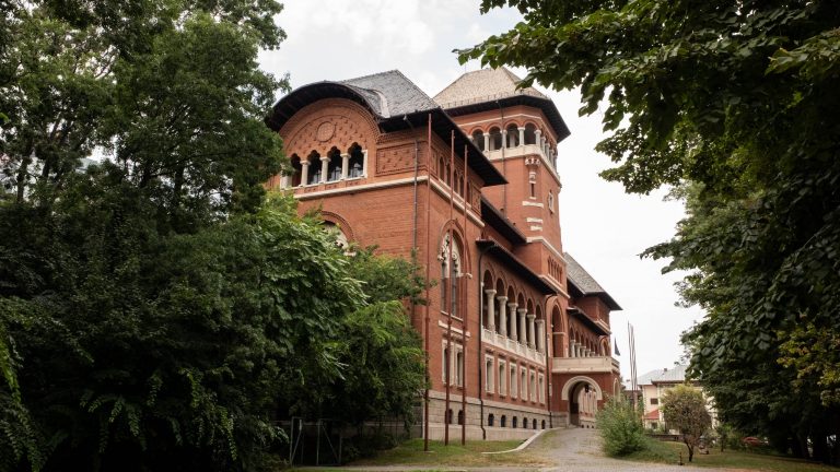Fațada principală din cărămidă roșie a Muzeului Național al Țăranului Român din București, prezentând elemente de arhitectură neoromânească și turnul central