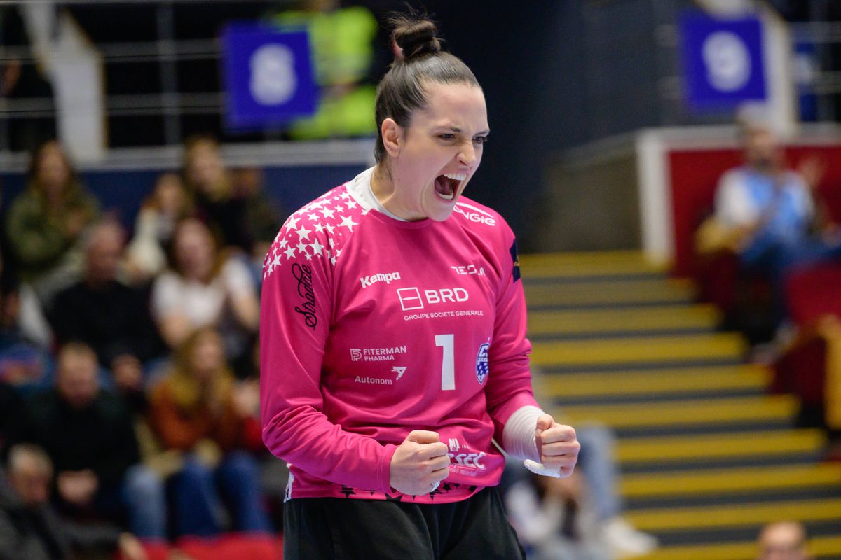 Portar de handbal feminin sărbătorind o intervenție decisivă în timpul unui meci oficial
