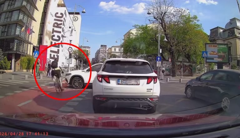 Biciclist surprins într-o situație periculoasă la intersecție în București, lângă o mașină care virează