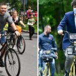 Doi bărbați mergând pe bicicletă într-un parc urban, în timpul unui eveniment public în aer liber