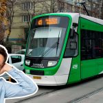 Bărbat deranjat de zgomotul unui tramvai Imperio verde care circulă pe stradă urbană