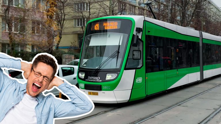 Bărbat deranjat de zgomotul unui tramvai Imperio verde care circulă pe stradă urbană