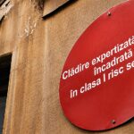 Clădire încadrată în clasa I de risc seismic cu bulină roșie montată pe fațadă în România