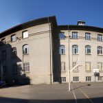 Clădirea Colegiului Național de Informatică Tudor Vianu, cu teren de baschet în curtea școlii, într-o zi senină de vară, București.