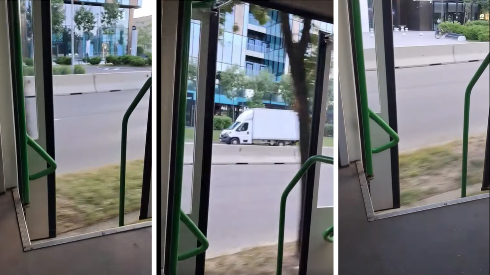 Tramvai în mers cu ușa deschisă, surprins din interior, pe o stradă urbană cu clădiri de birouri în fundal.
