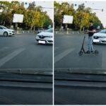Bărbat pe trotinetă electrică traversând o intersecție aglomerată, în apropierea unor autoturisme.