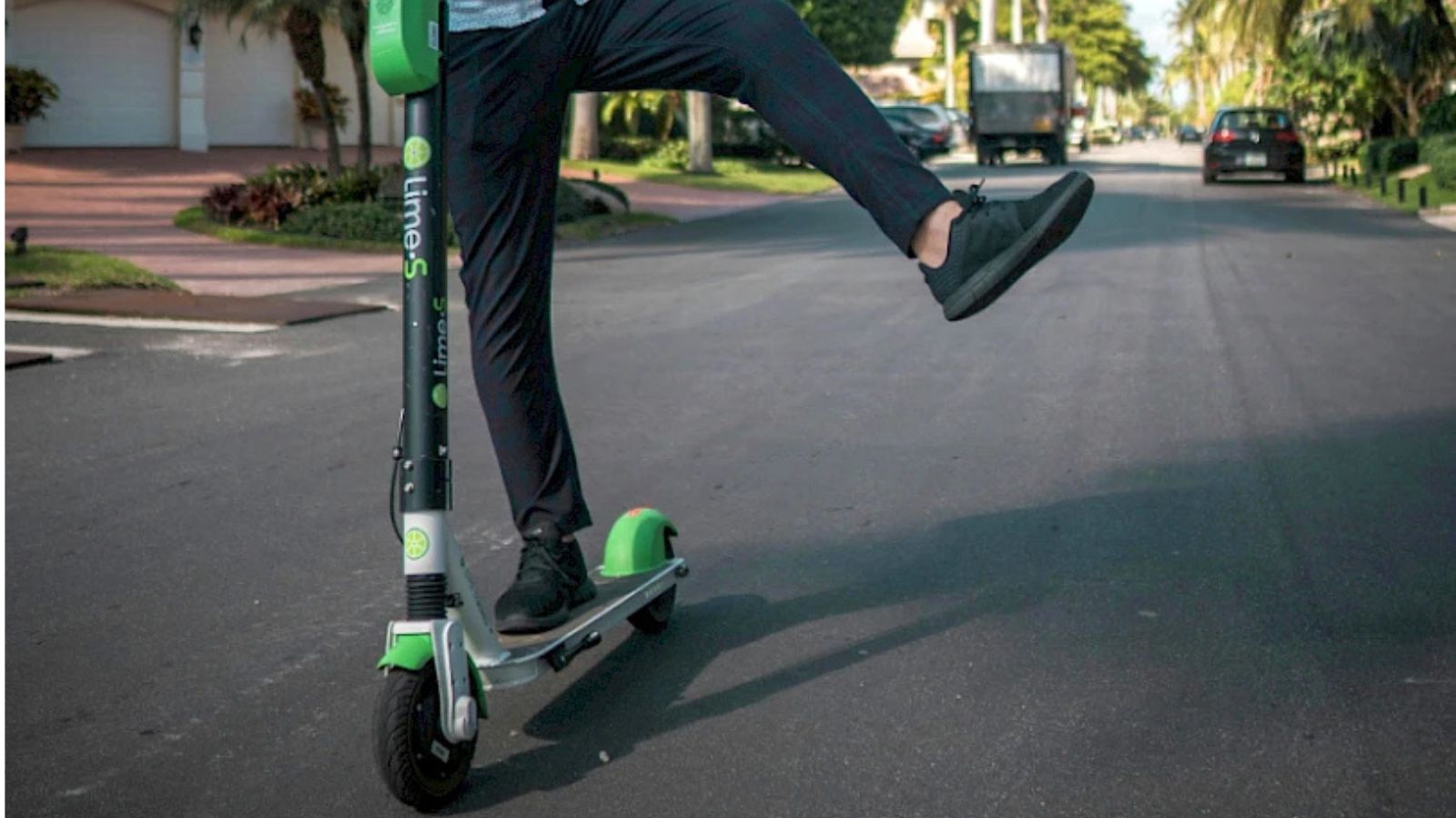 Persoană care merge pe o trotinetă electrică Lime pe o stradă urbană
