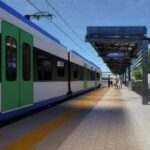 Tren metropolitan București-Ilfov oprit într-o stație modernă, cu peron acoperit și acces pentru călători.