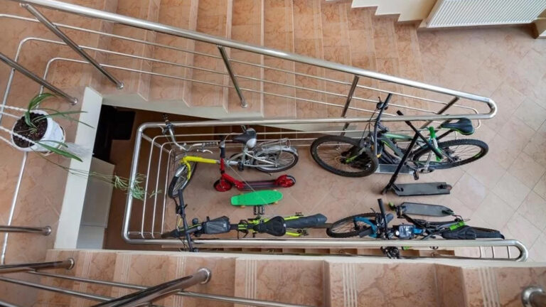 Biciclete și trotinete depozitate pe casa scării, în spațiul comun al unui bloc