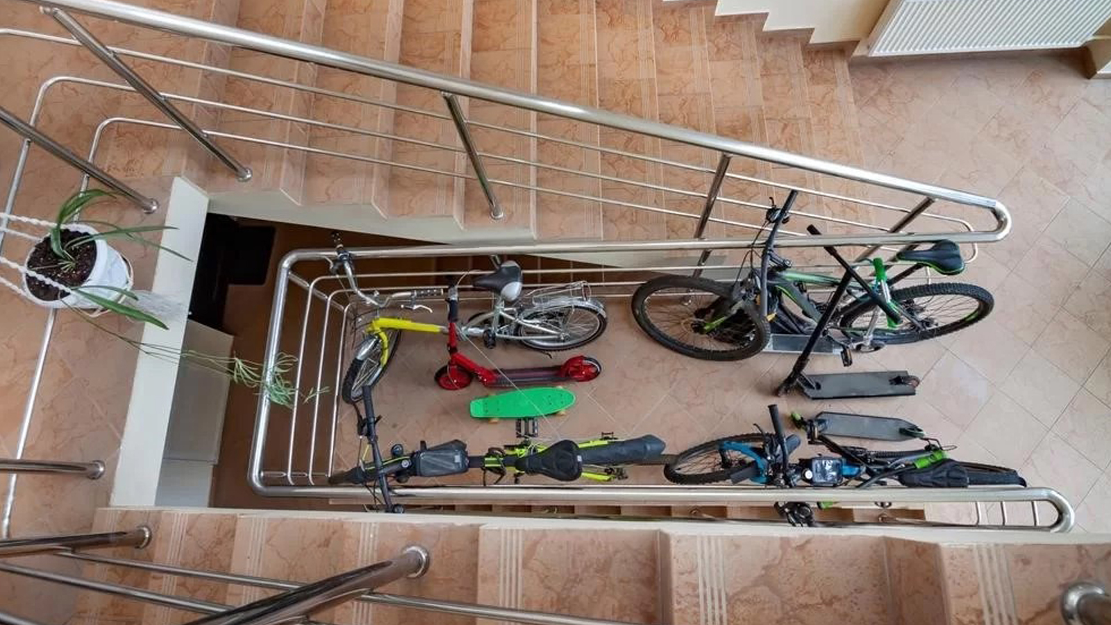 Biciclete și trotinete depozitate pe casa scării, în spațiul comun al unui bloc
